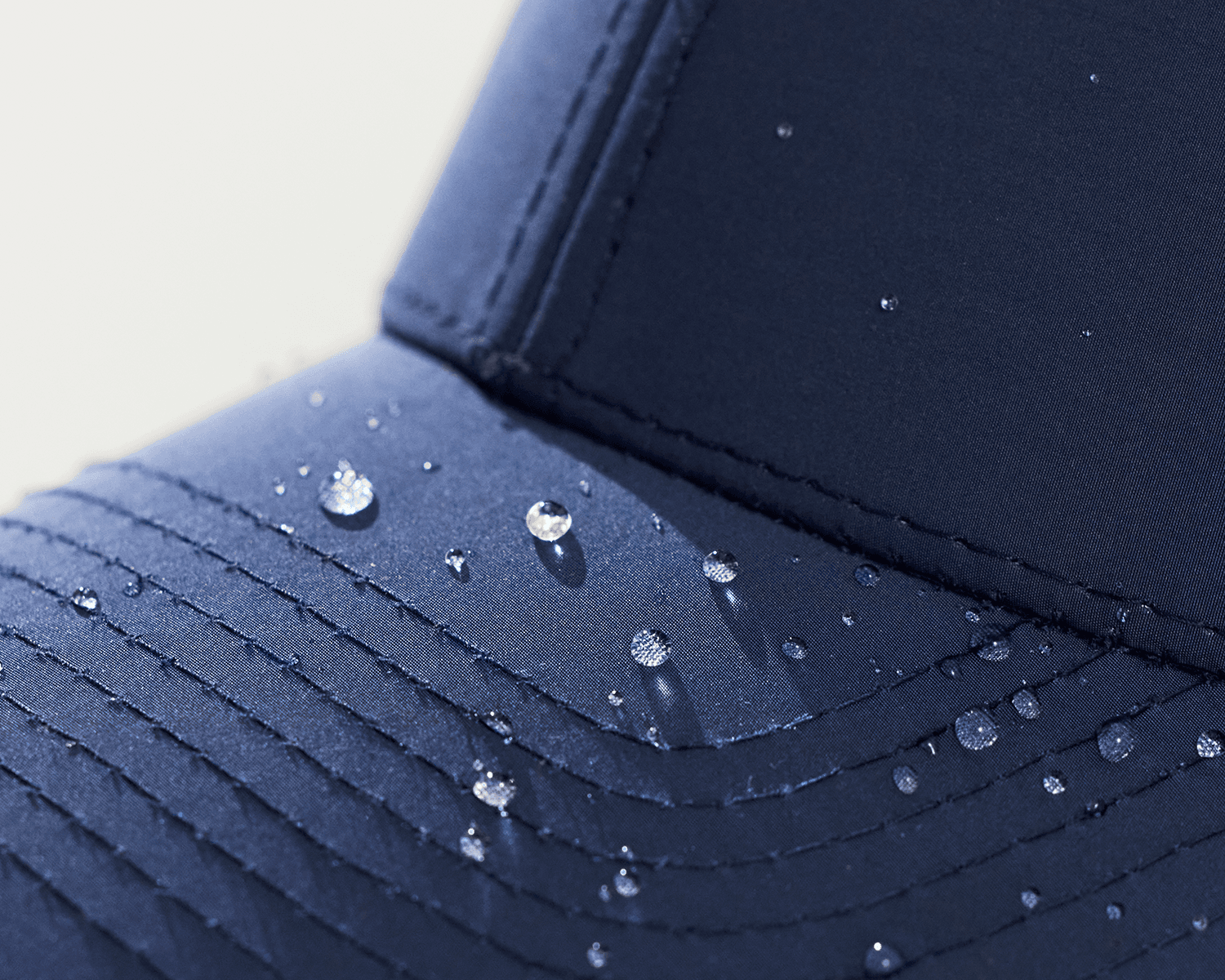 close view of a navy sport cap from varsity headwear with with water drops