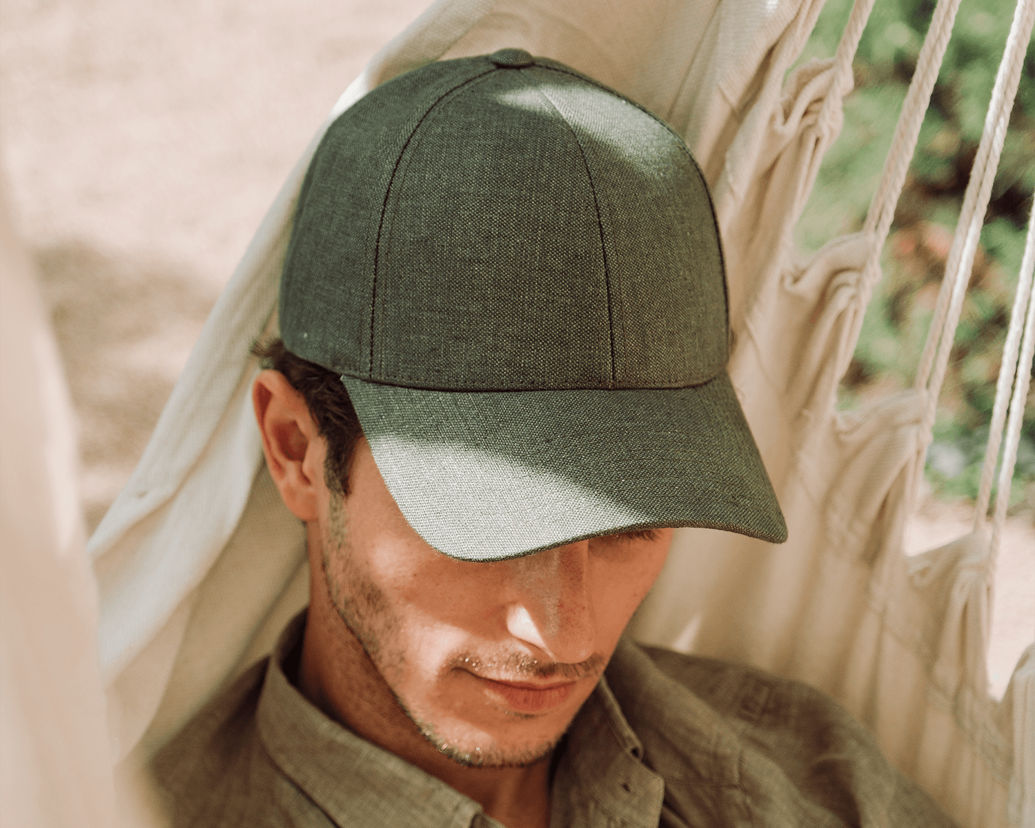 Front view of male model wearing a legacy structured french olive cap in summer environment