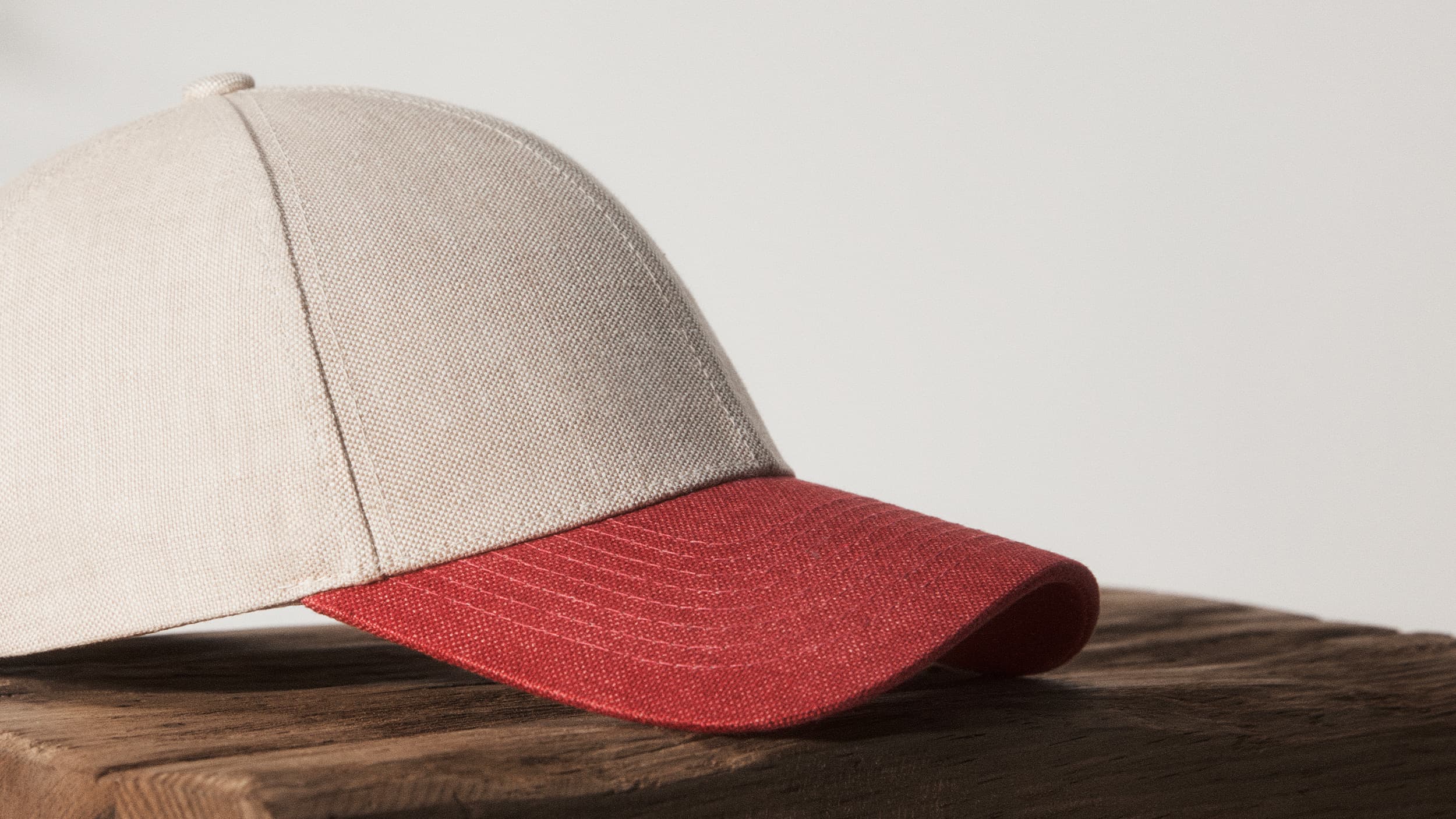 Side view of an hampton beige and amaranth red linen cap from varsity headwear