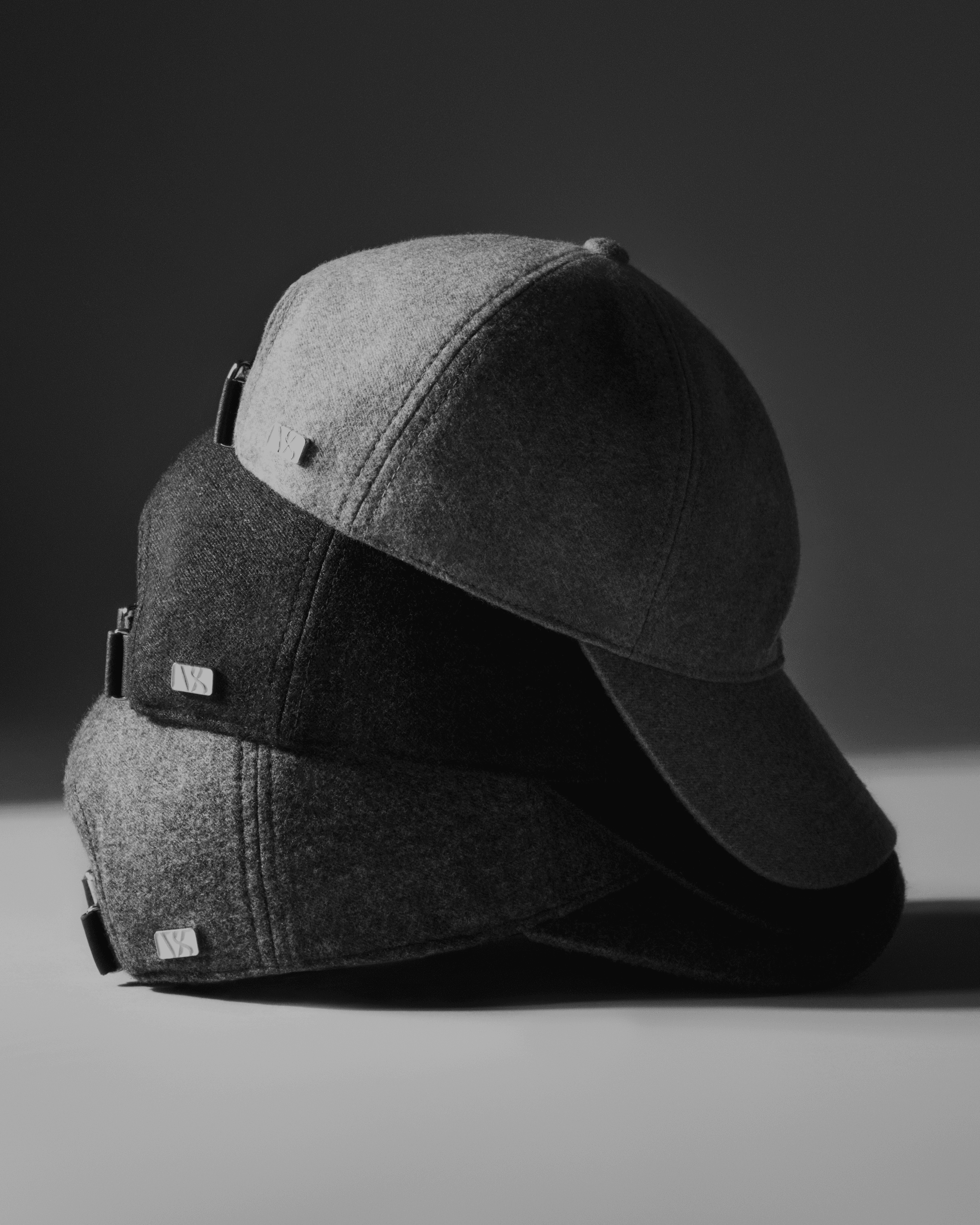 Side view of three loro piana cashmere caps from varsity headwear in colors beige, navy and grey