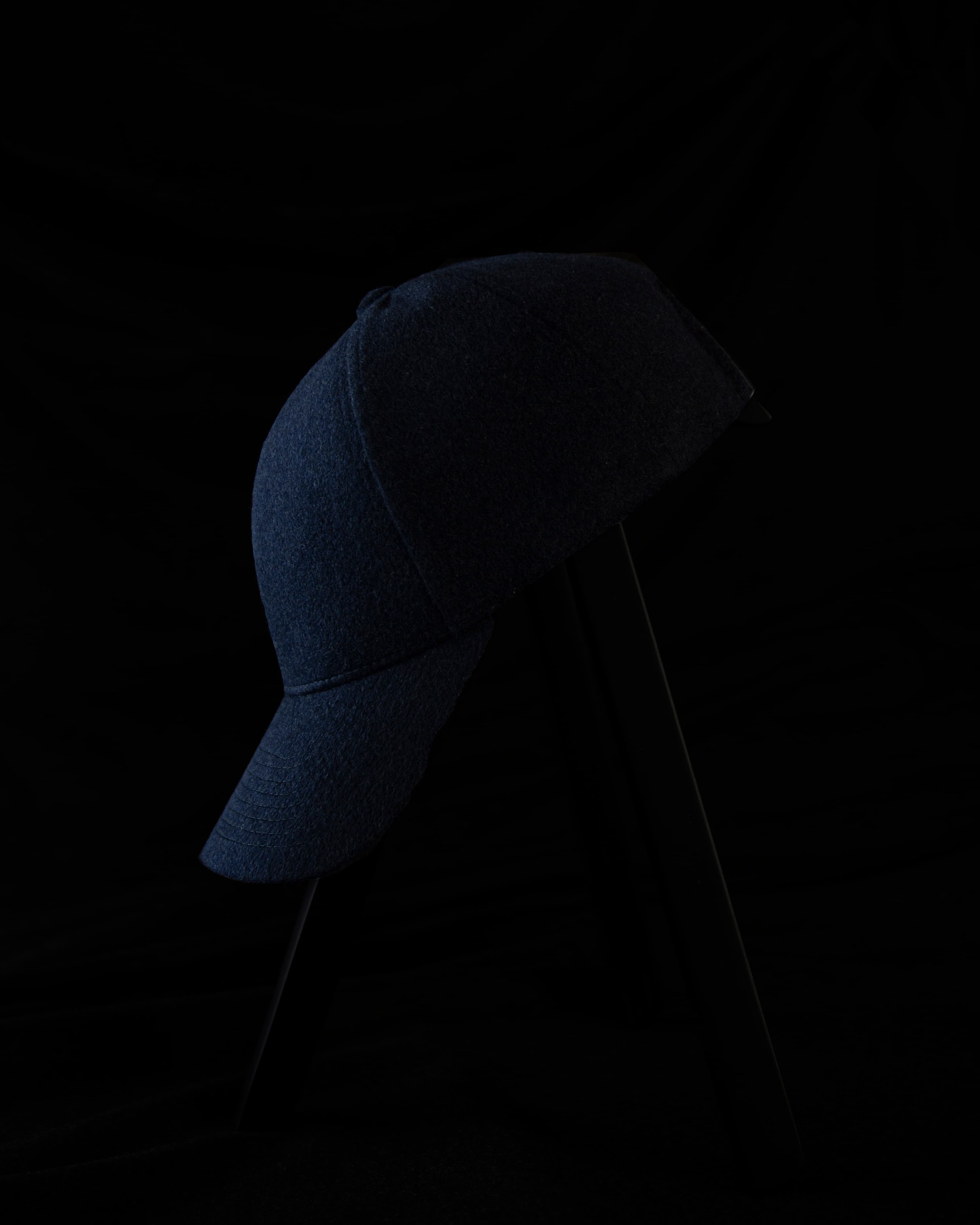 Dark image of a side view of a blue cap