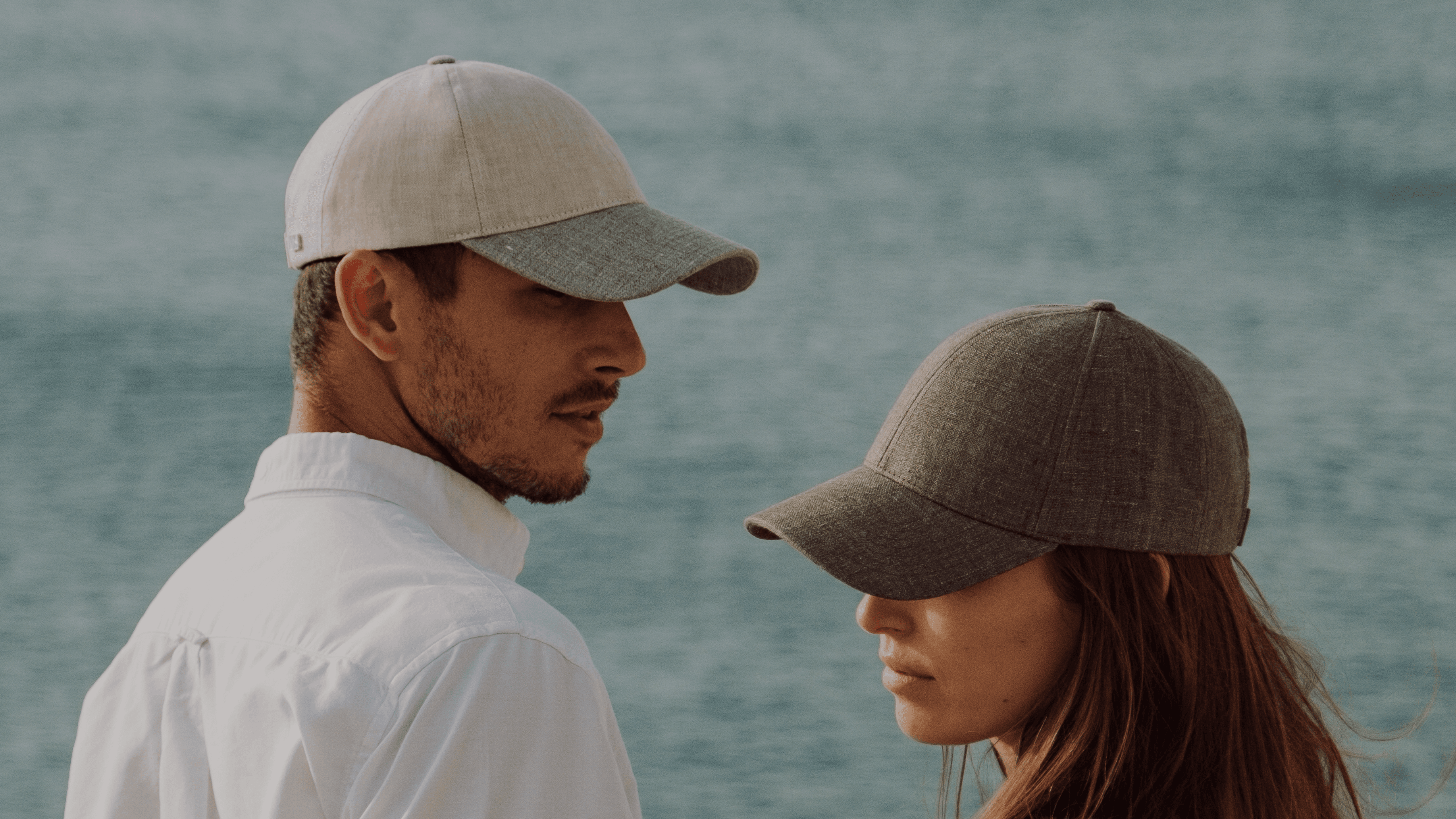 Side view of female and male model wearing linen caps for the summer 2024 campaing shoot