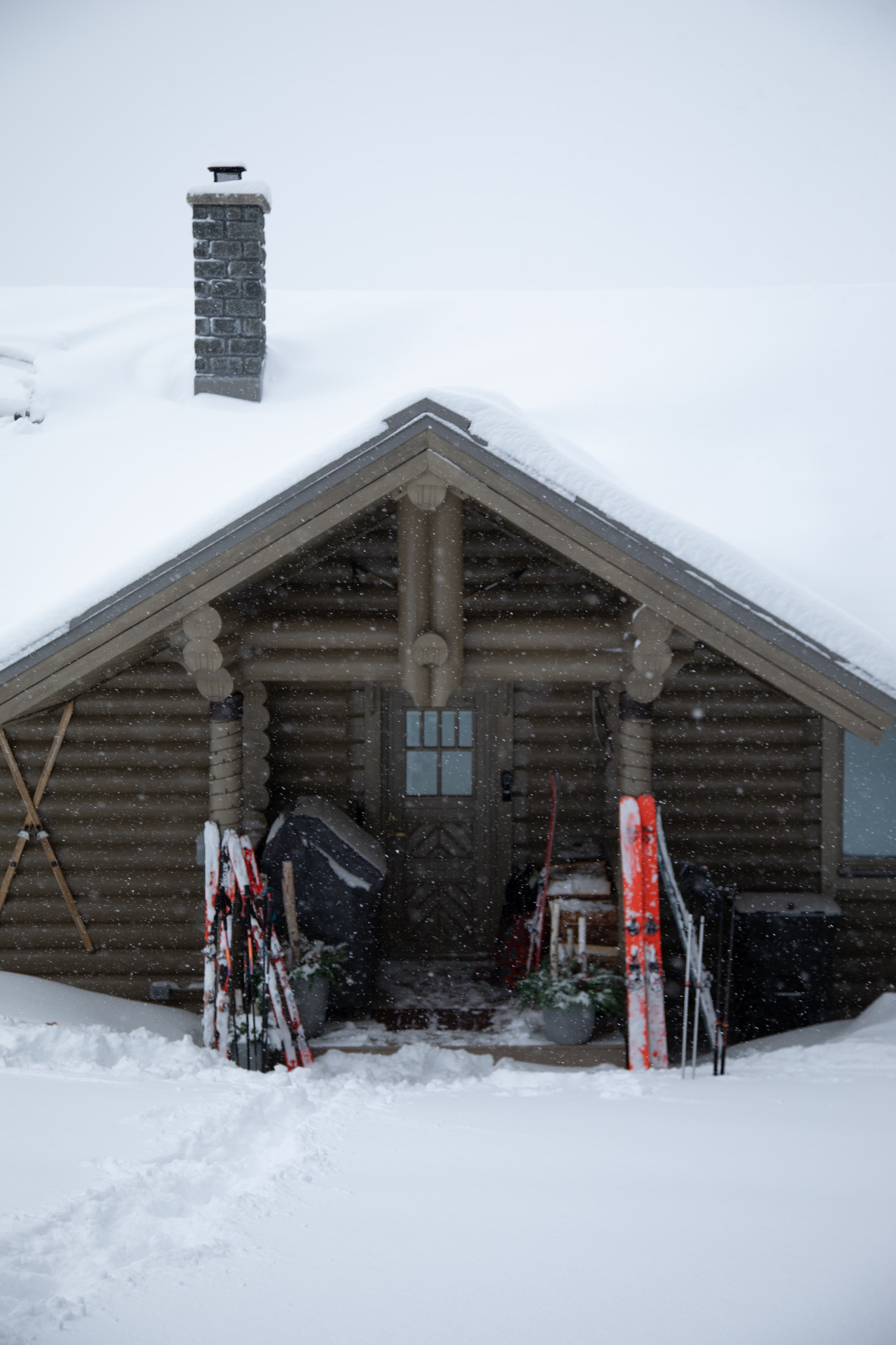 Front view of cabin in snow with skis in front