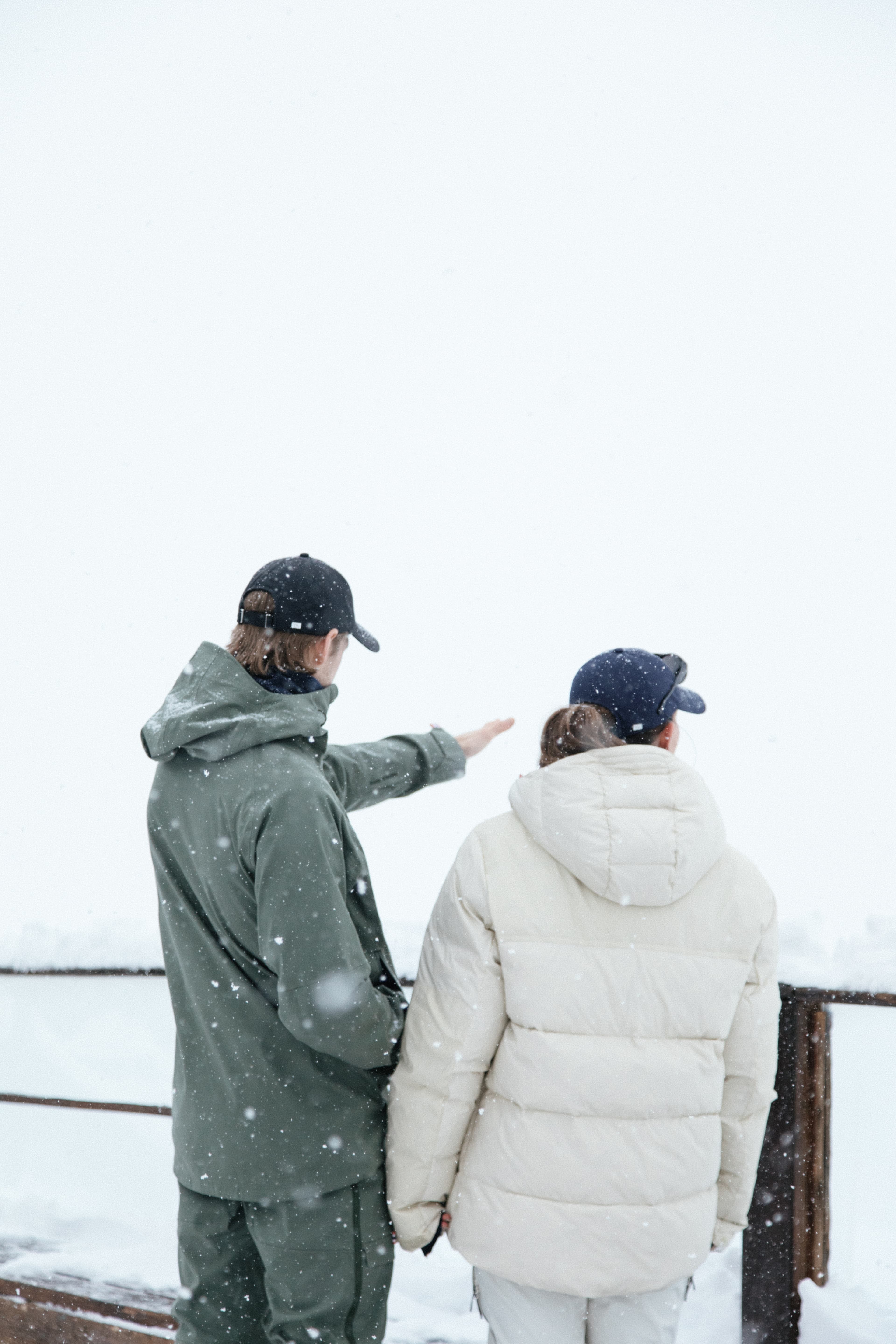 Back view of female and male wearing active tech in snowy environment