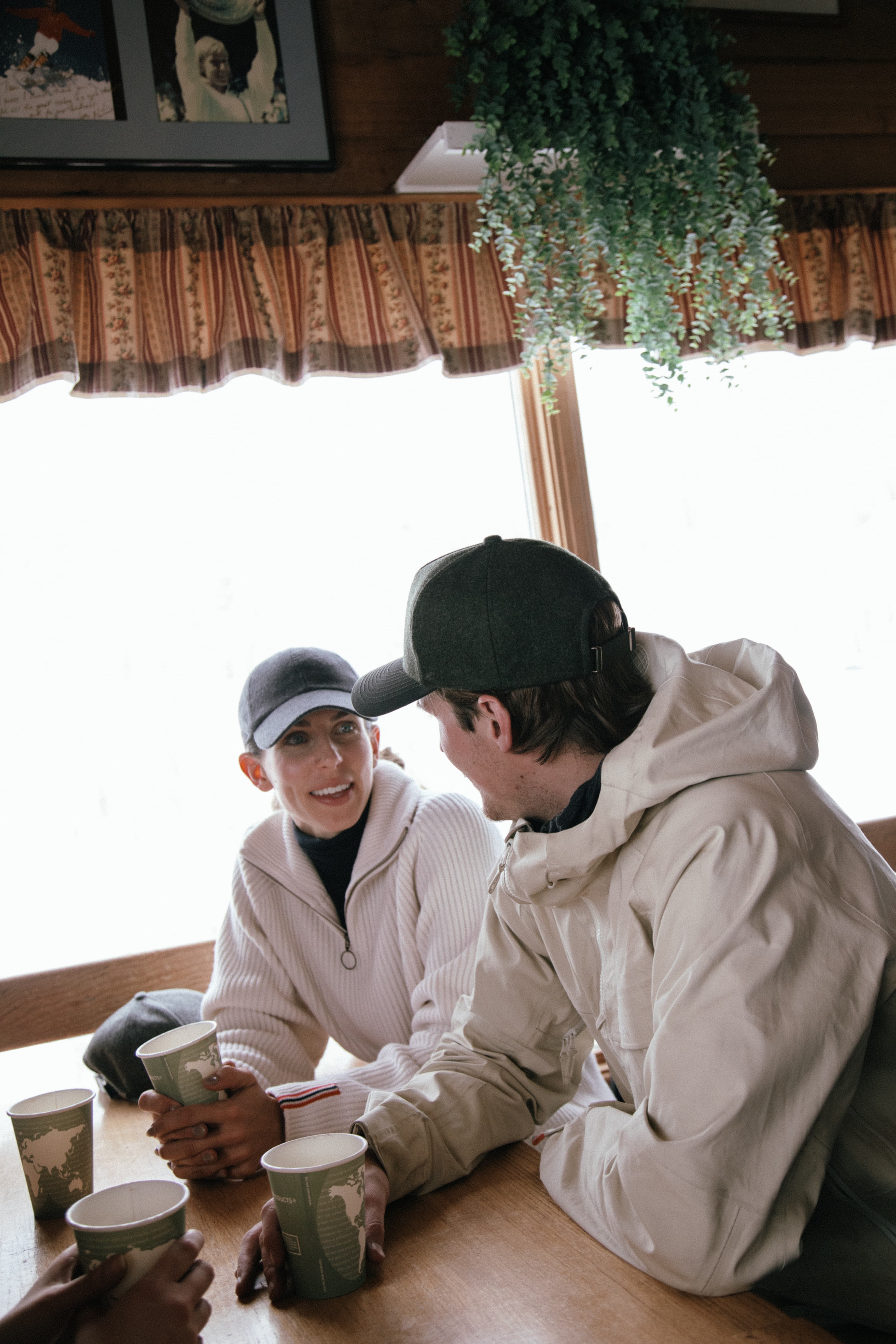 Side view of female and male wearing varsity headwear caps at Bonnies resturant in Aspen